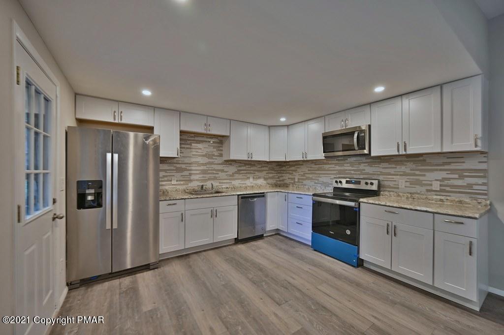 102 Forest Road Dingmans Ferry, PA 18328 - Photo 16 of 75 a kitchen with granite countertop stainless steel appliances and wooden cabinets