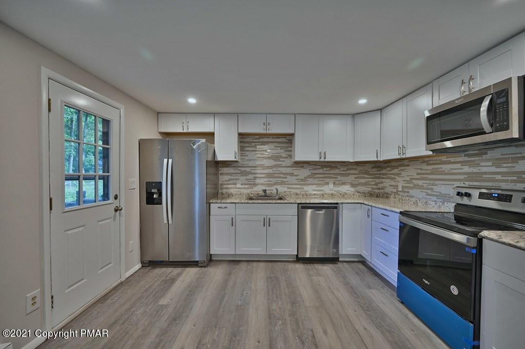 102 Forest Road Dingmans Ferry, PA 18328 - Photo 17 of 75 a kitchen with stainless steel appliances granite countertop a refrigerator stove top oven and sink