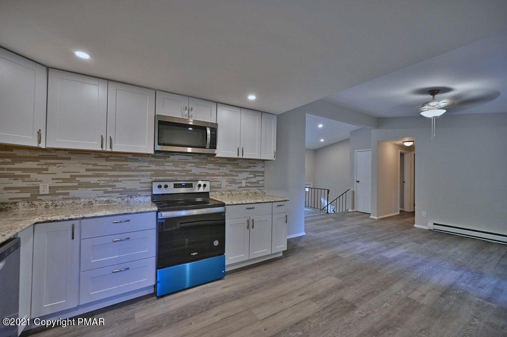 102 Forest Road Dingmans Ferry, PA 18328 - Photo 19 of 75 a kitchen with granite countertop wooden cabinets stainless steel appliances and a counter space