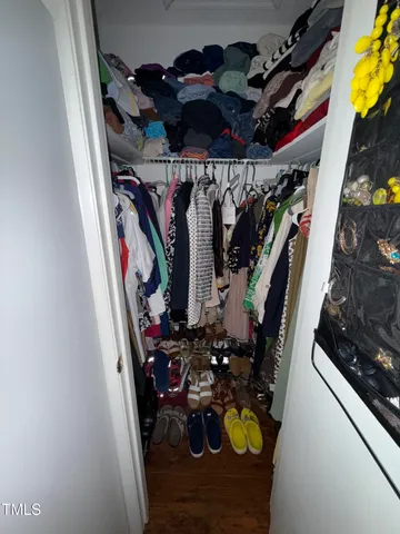 a view of walk in closet with clothes and shoes