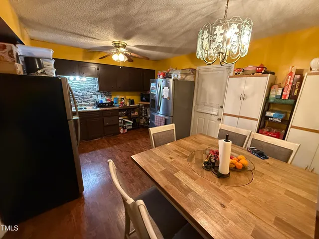 a view of a dining room with furniture a chandelier and wooden floor