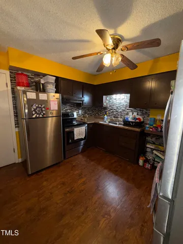 a kitchen with stainless steel appliances granite countertop a refrigerator and a stove top oven