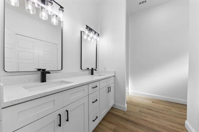 a bathroom with a double vanity sink and a mirror