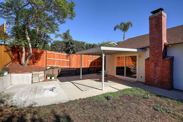 a view of a patio with a table chairs and a small yard