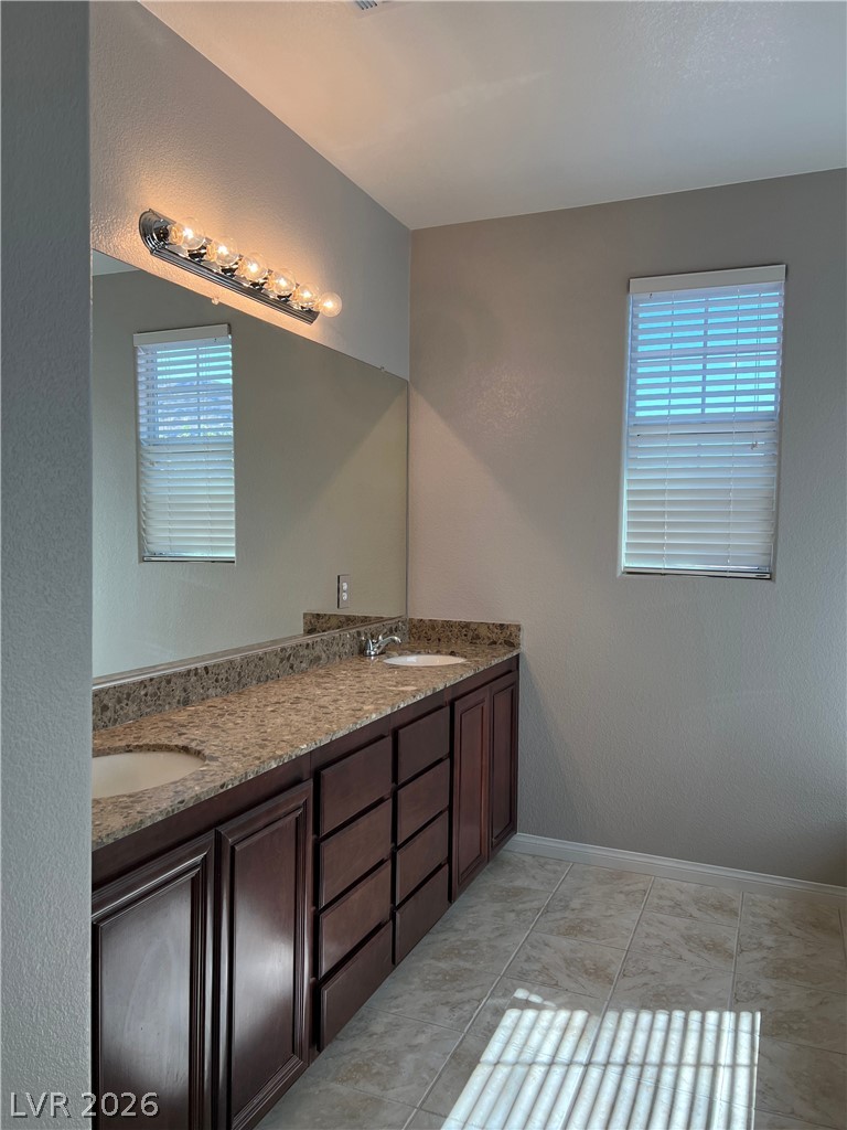 5981 Honeysuckle Ridge Street Las Vegas, NV 89148 - Photo 10 of 29 Double vanity with granite counters and tiled flooring offers convenience and style.