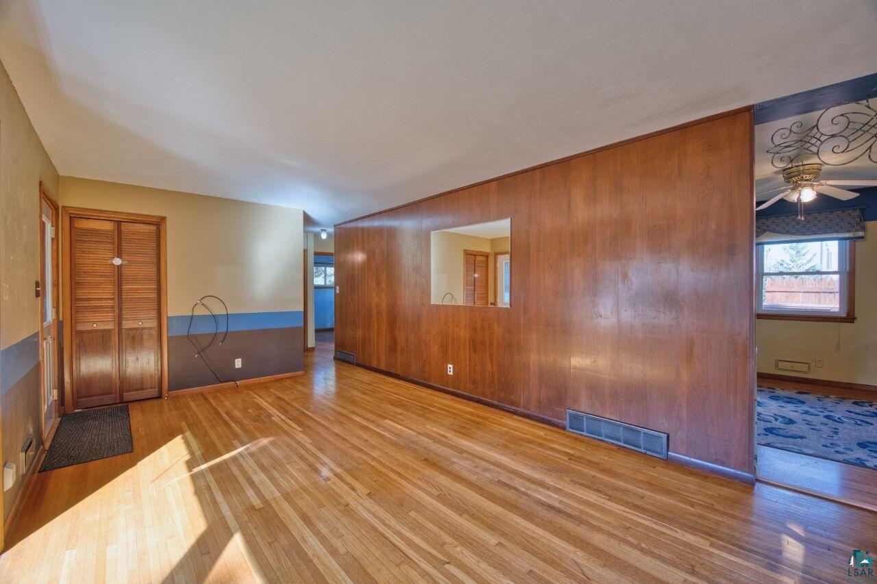 5316 Highway 110 Aurora, MN 55705 - Photo 6 of 35 Spare room featuring wooden walls, wood-type flooring, and ceiling fan