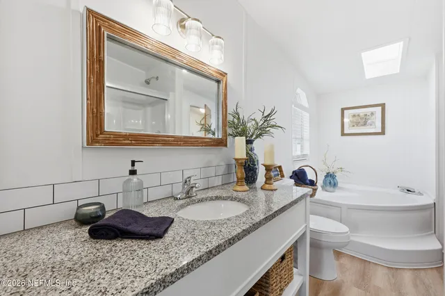 a bathroom with a toilet a sink and a window