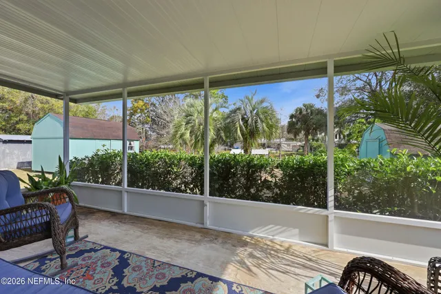 a palm tree sitting in front of a building with trees