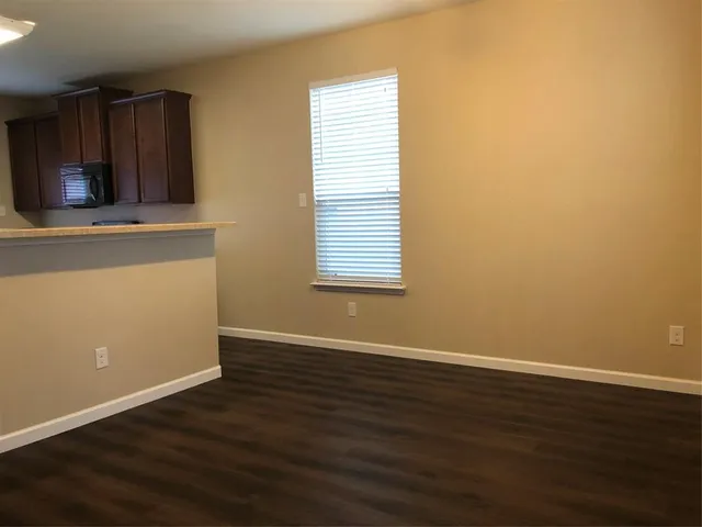 an empty room with wooden floor and a window