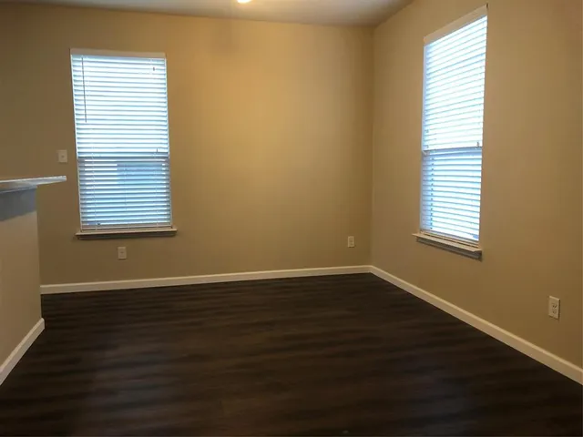 an empty room with wooden floor and a window
