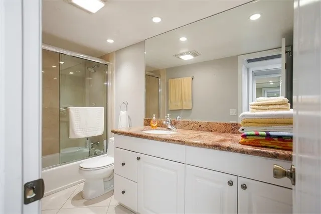 a bathroom with a granite countertop sink toilet and shower