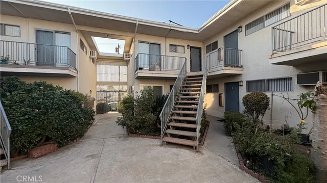 a view of a house with many windows and plants