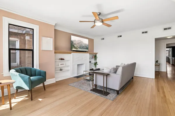 a living room with furniture a flat screen tv and wooden floor