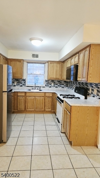 306 1st Street, Unit 1 Elizabeth Port, NJ 07206 - Photo 8 of 23 a kitchen with stainless steel appliances granite countertop a stove top oven a sink dishwasher and a refrigerator