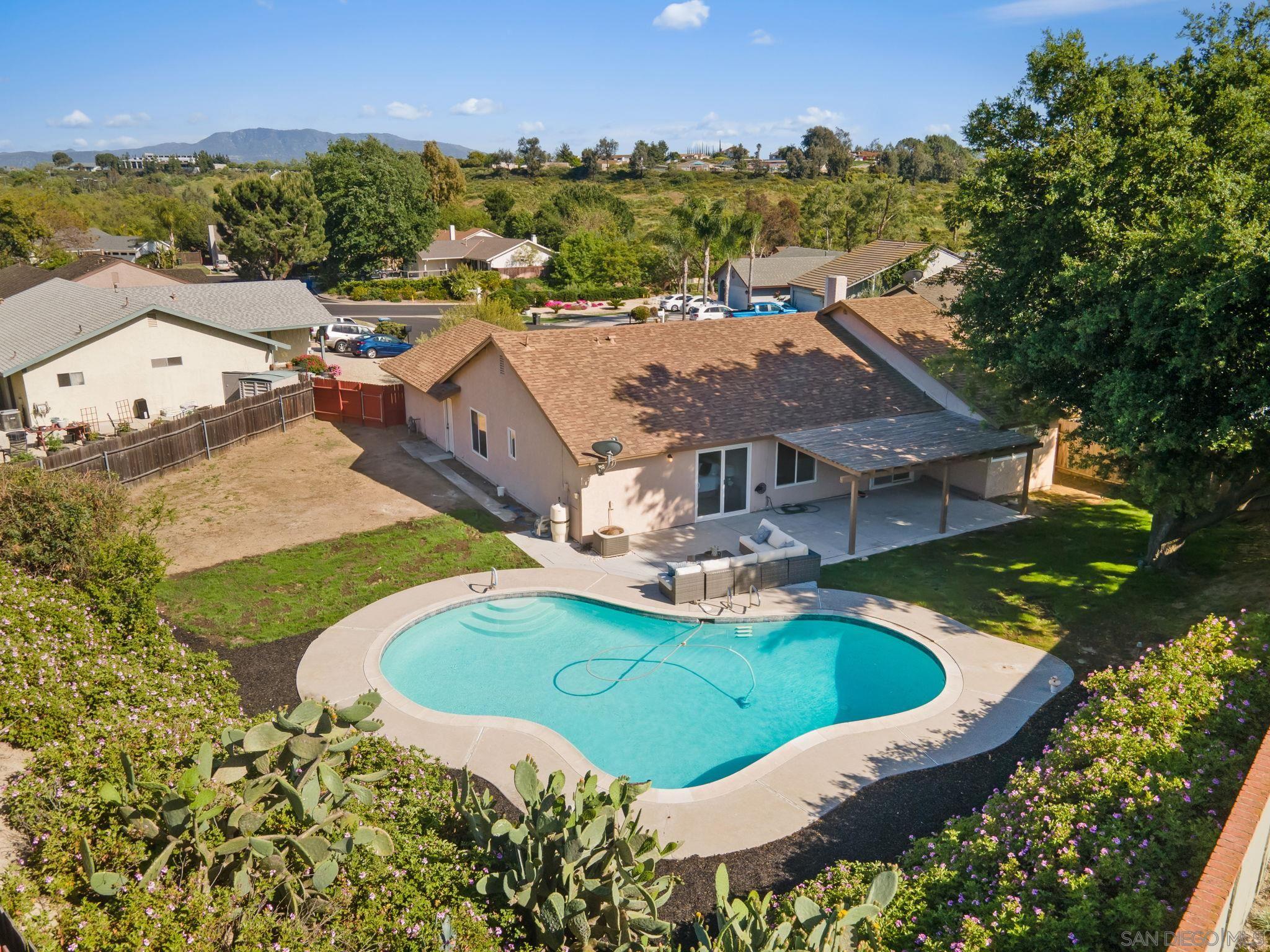 an aerial view of a house having swimming pool a yard and mountain view