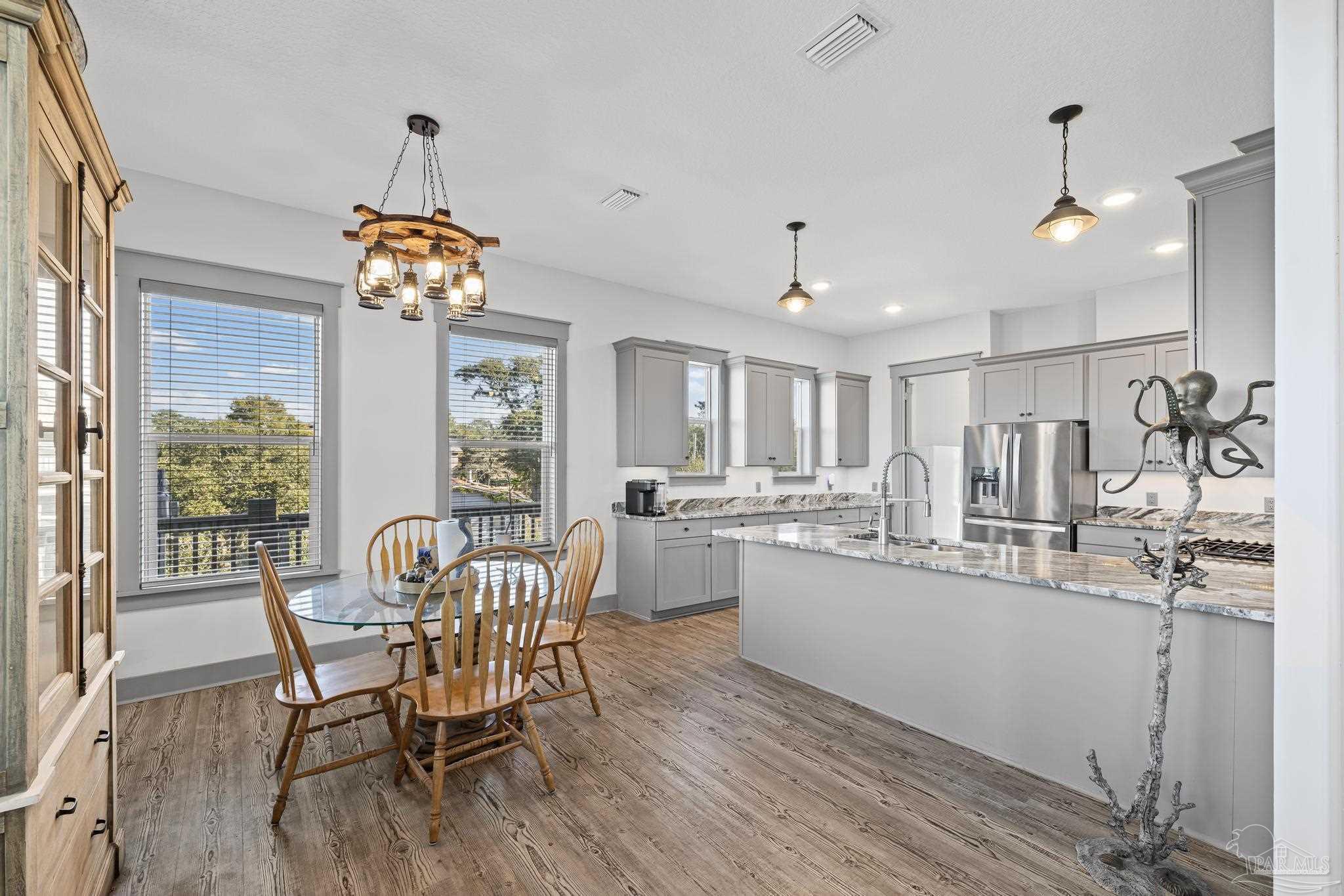 305 Garcon Point Road Milton, FL 32583 - Photo 17 of 72 a kitchen with a dining table chairs and chandelier