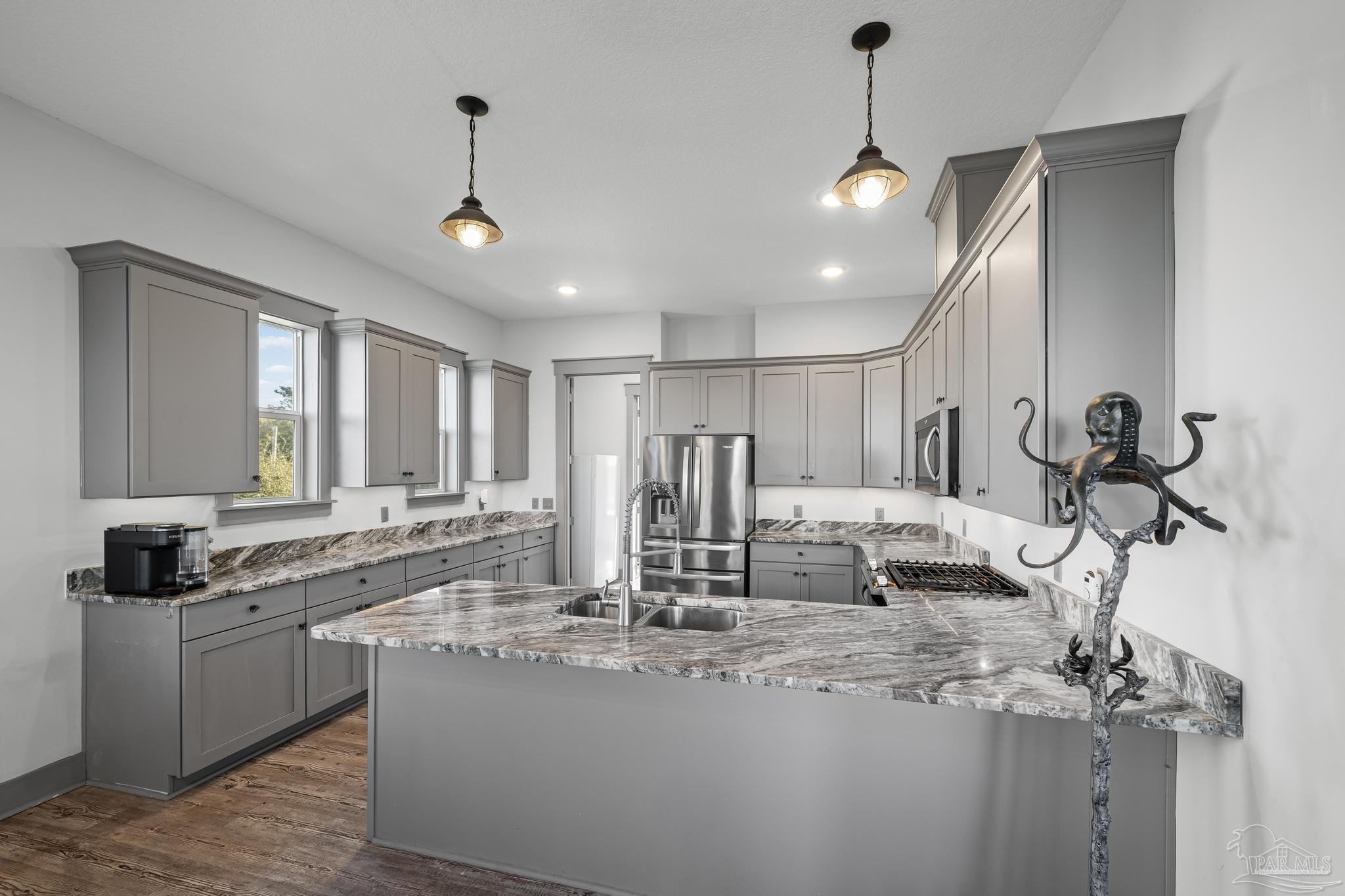 305 Garcon Point Road Milton, FL 32583 - Photo 21 of 72 a kitchen with kitchen island granite countertop a sink appliances and cabinets
