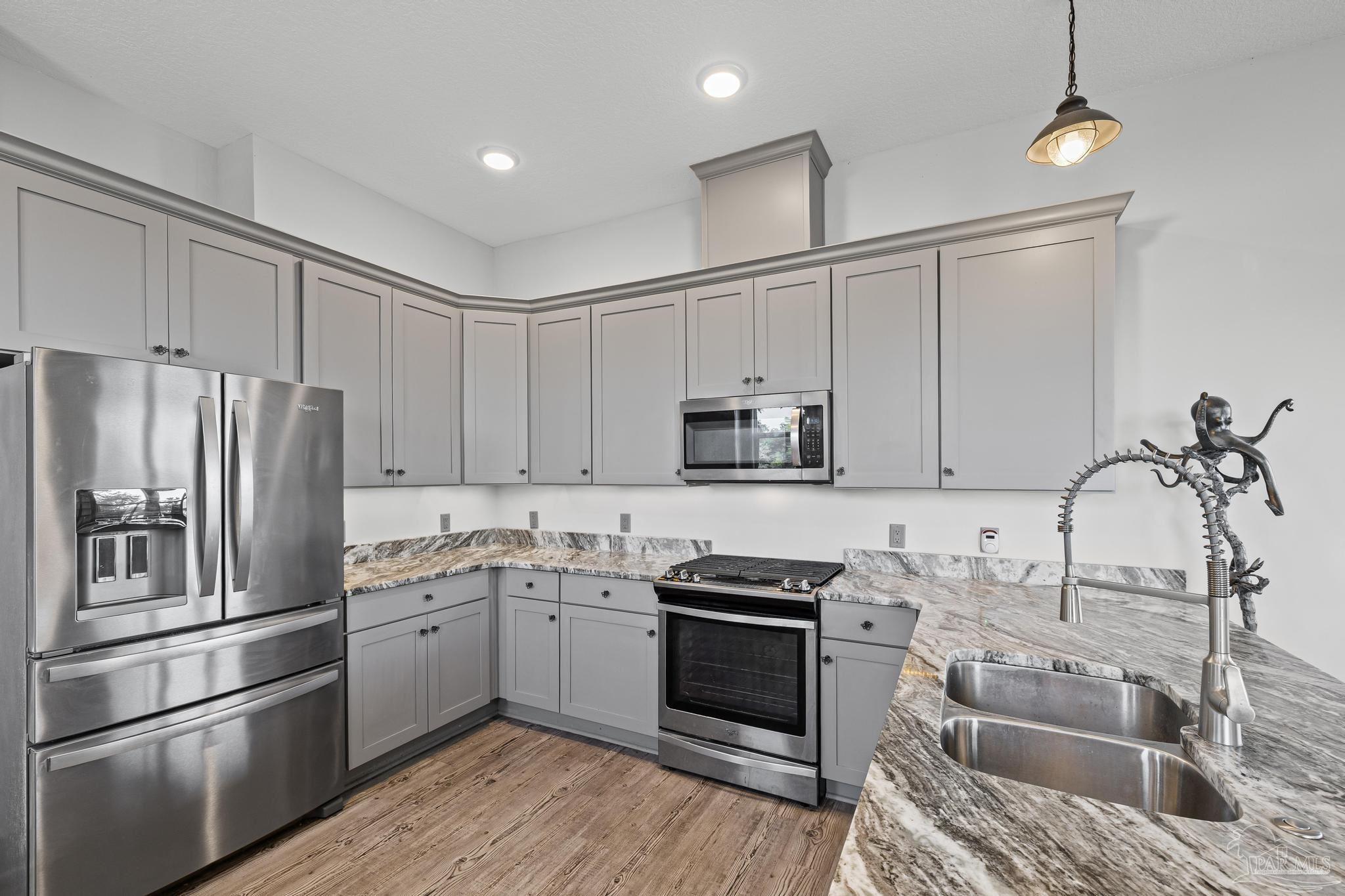 305 Garcon Point Road Milton, FL 32583 - Photo 22 of 72 a kitchen with stainless steel appliances granite countertop a refrigerator sink and stove