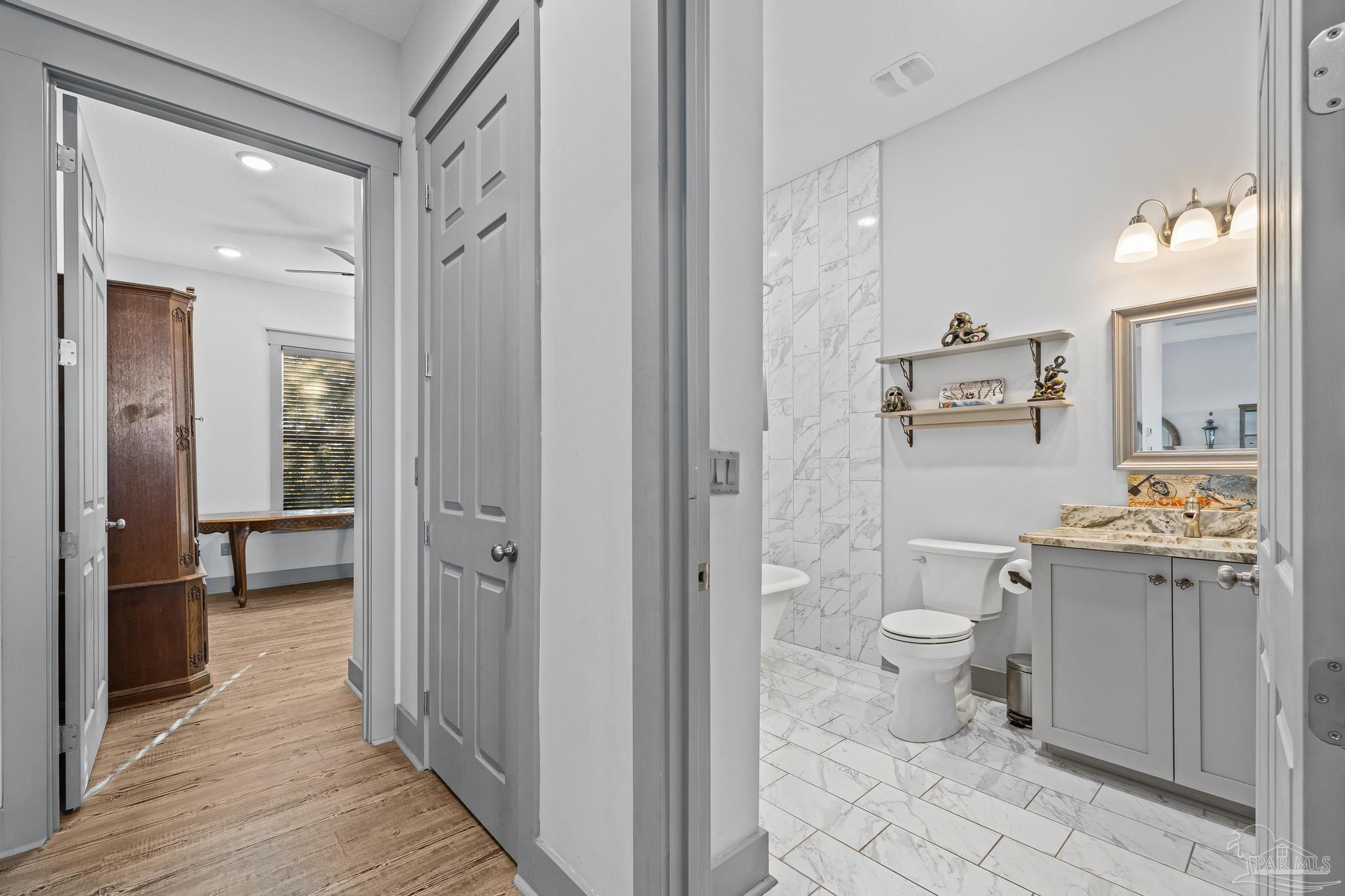305 Garcon Point Road Milton, FL 32583 - Photo 28 of 72 a bathroom with a granite countertop toilet a sink and a mirror