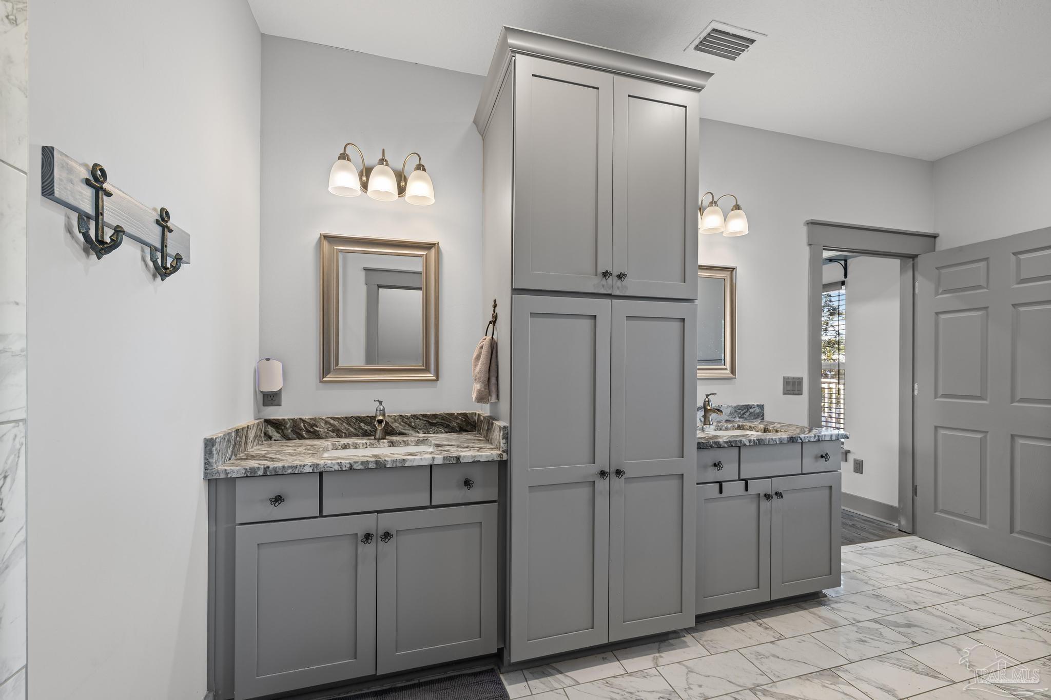 305 Garcon Point Road Milton, FL 32583 - Photo 42 of 72 a bathroom with a double vanity sink and a mirror