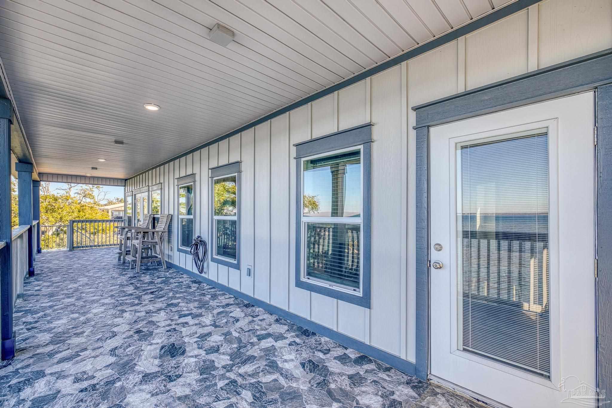 305 Garcon Point Road Milton, FL 32583 - Photo 44 of 72 a view of a hallway with wooden floor and windows