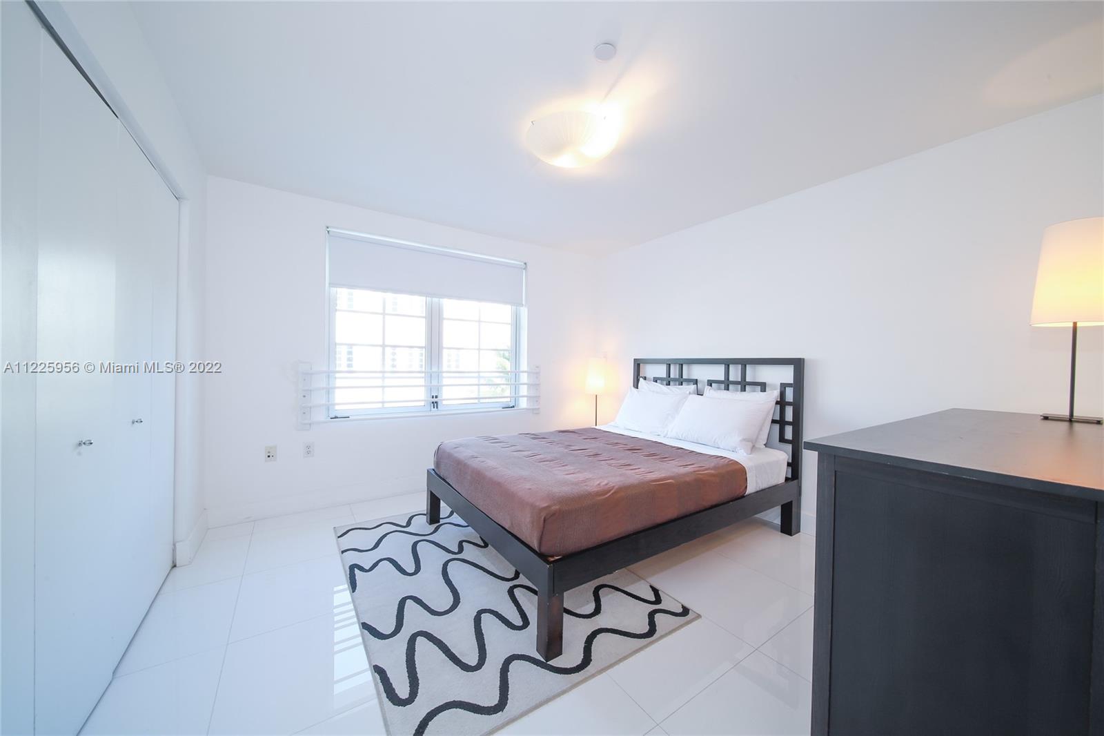 Flamingo-Lummus Miami Beach, FL 33139 - Photo 23 of 28 a bedroom with a bed and a table in it