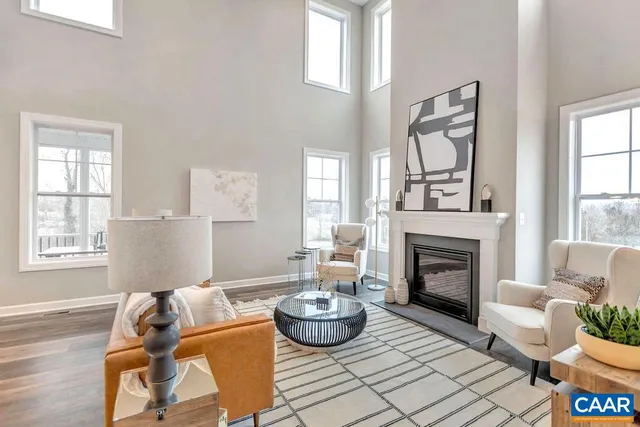 a living room with furniture a fireplace and a large window
