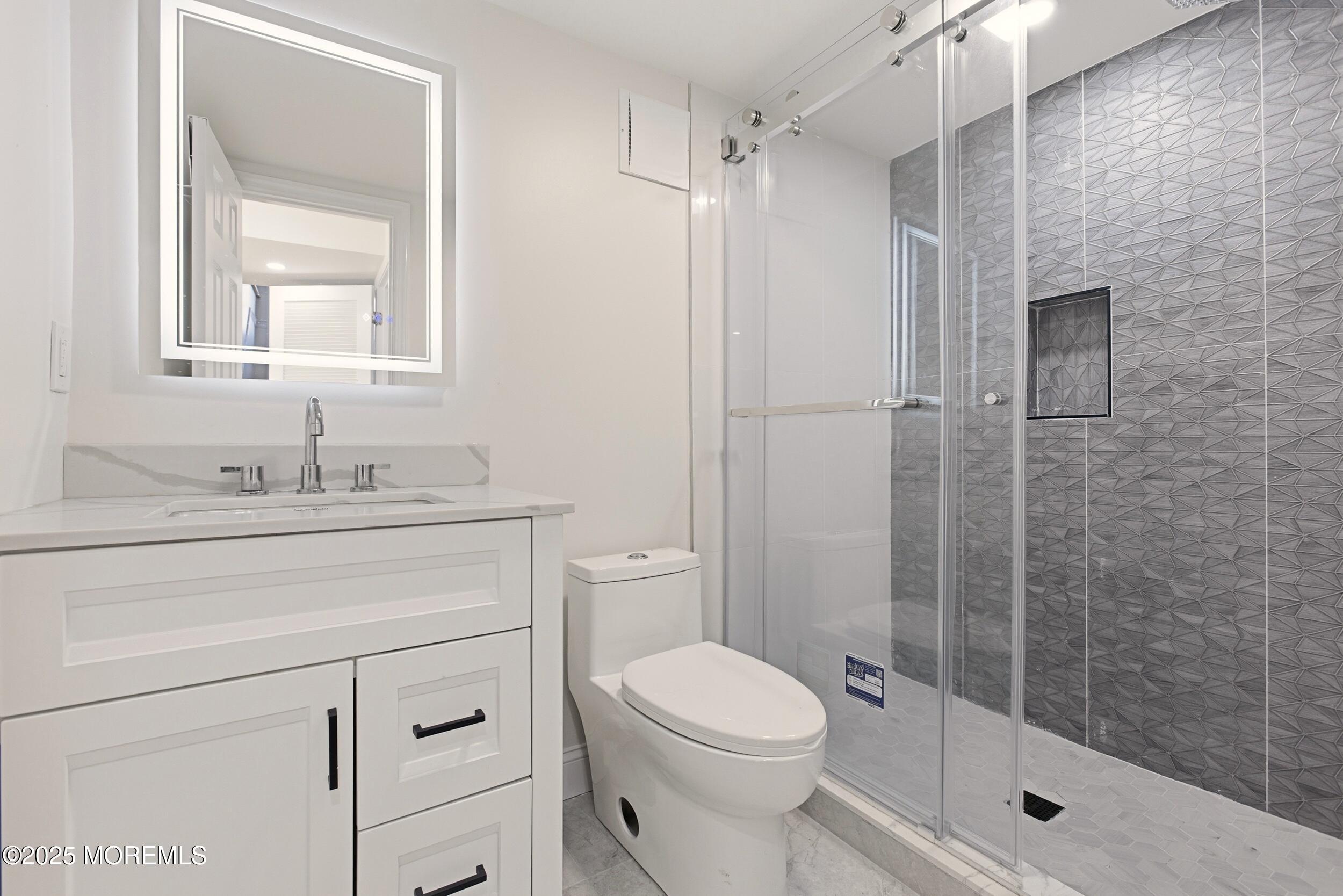 75 Hickory Hill Road Jackson, NJ 08527 - Photo 26 of 30 a bathroom with a granite countertop toilet a sink a mirror and shower