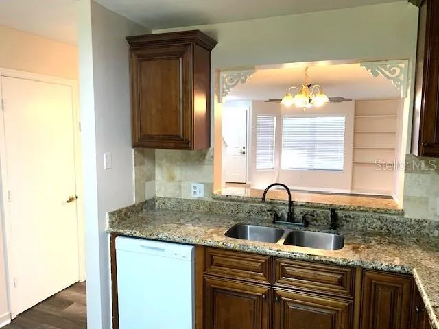 a kitchen with granite countertop a sink and cabinets