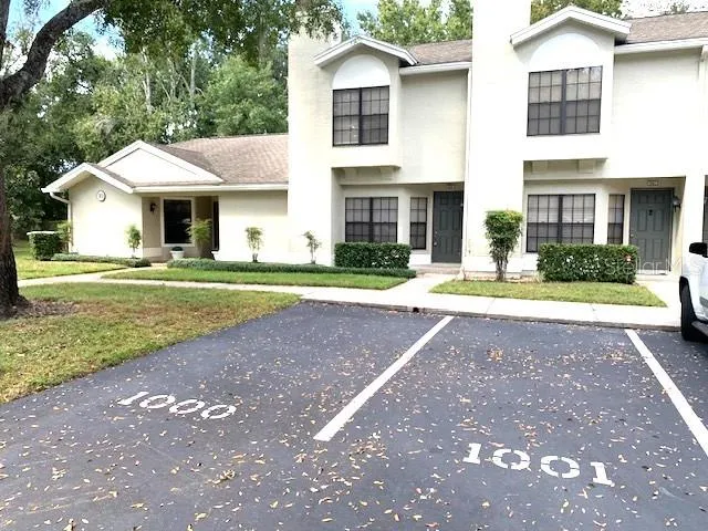 a front view of a house with a yard and trees
