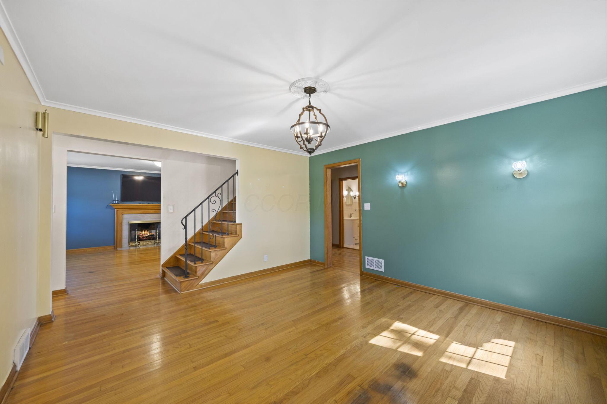 40 South Kellner Road Columbus, OH 43209 - Photo 16 of 57 Wood-finish flooring throughout, ornate wrought iron staircase, built-in wall sconces, and a decorative ceiling medallion with a chandelier