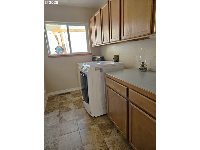 a utility room with cabinets washer and dryer