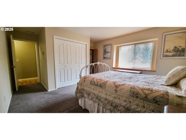 a bedroom with a bed and a painting on the wall