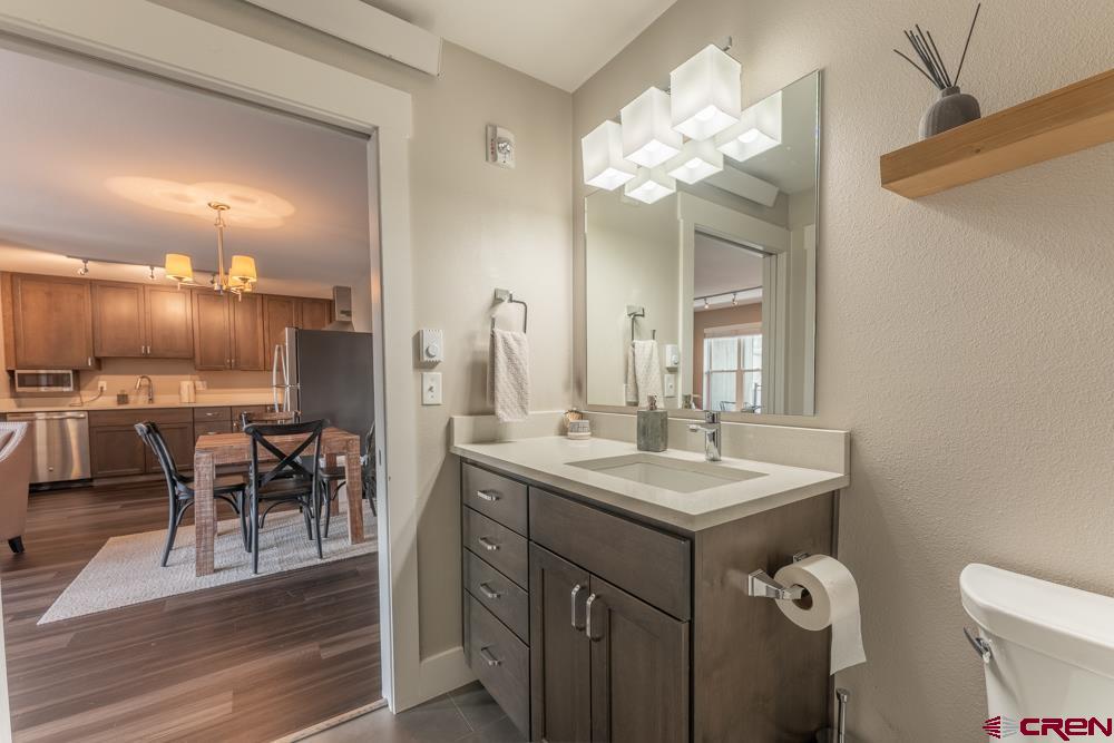 20 Marcellina Lane, Unit 104 Crested Butte, CO 81225 - Photo 11 of 28 a bathroom with a granite countertop sink a toilet and a mirror