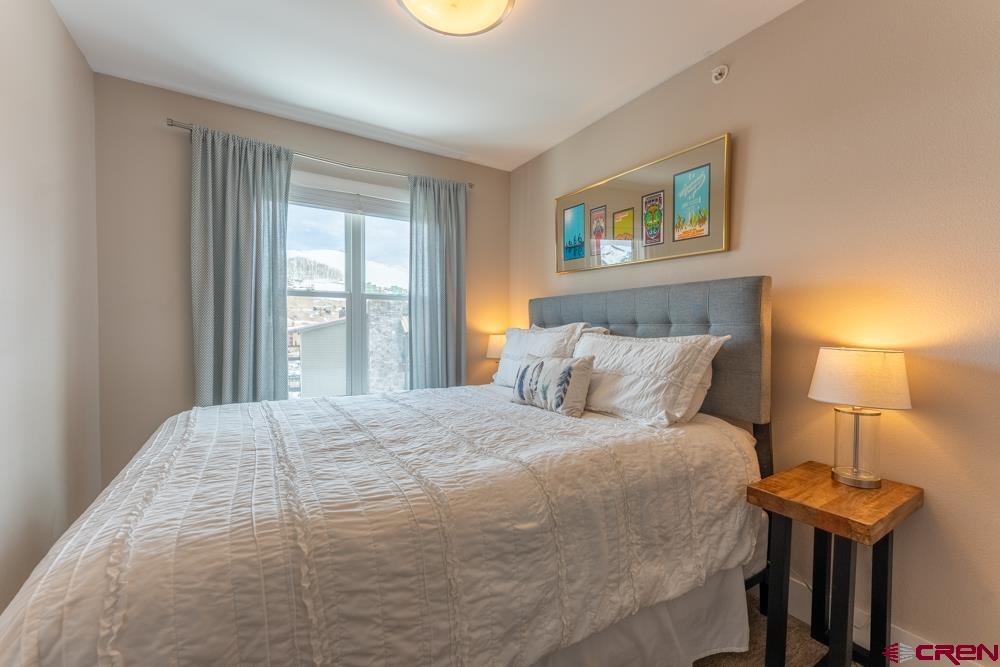 20 Marcellina Lane, Unit 104 Crested Butte, CO 81225 - Photo 26 of 28 a bedroom with a bed and a lamp