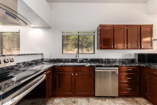 a kitchen with stainless steel appliances granite countertop a stove and a refrigerator