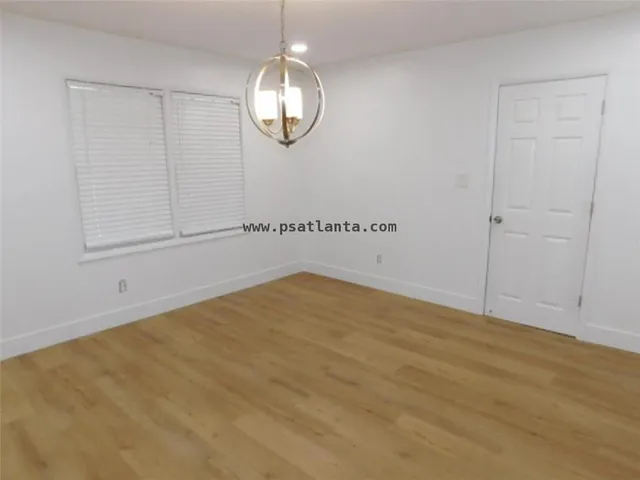 an empty room with wooden floor and mirror