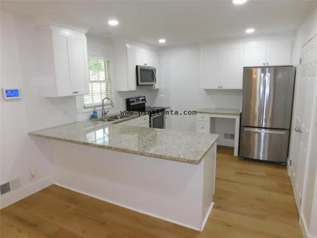a kitchen with stainless steel appliances granite countertop a sink a refrigerator and a granite counter tops