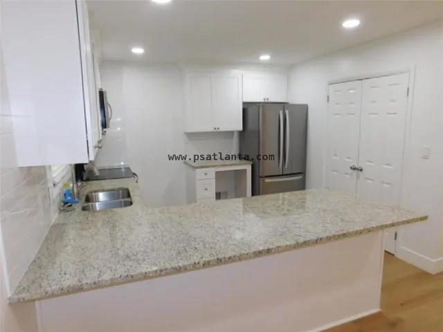 a kitchen with stainless steel appliances granite countertop a sink refrigerator and microwave