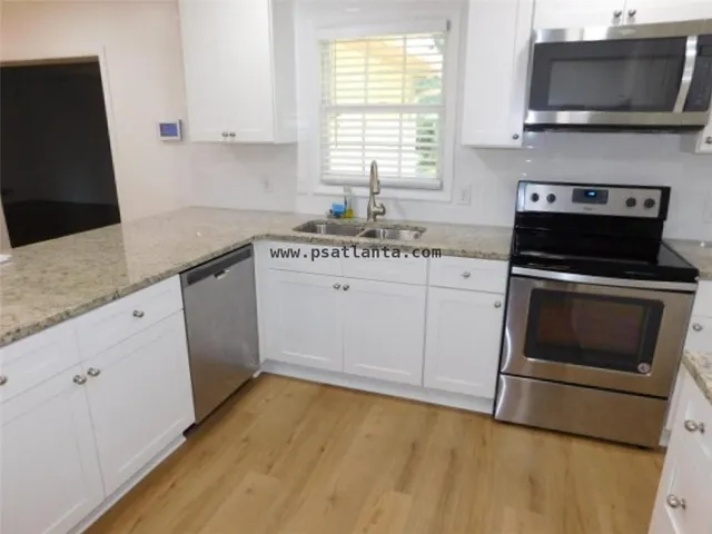 a kitchen with a sink stove and microwave