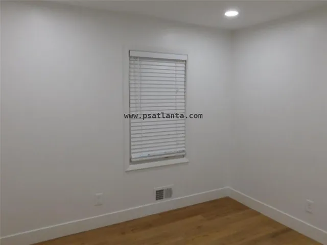 a view of a small space with wooden floor and a window