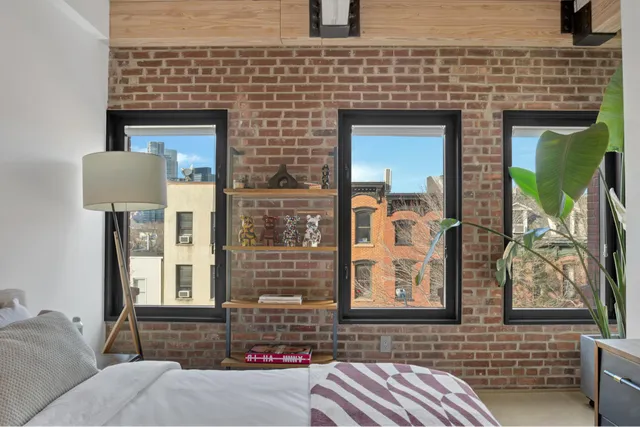 a bedroom with a bed a large window and flat screen tv