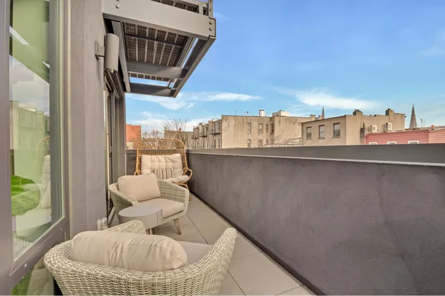 a balcony with table and chairs