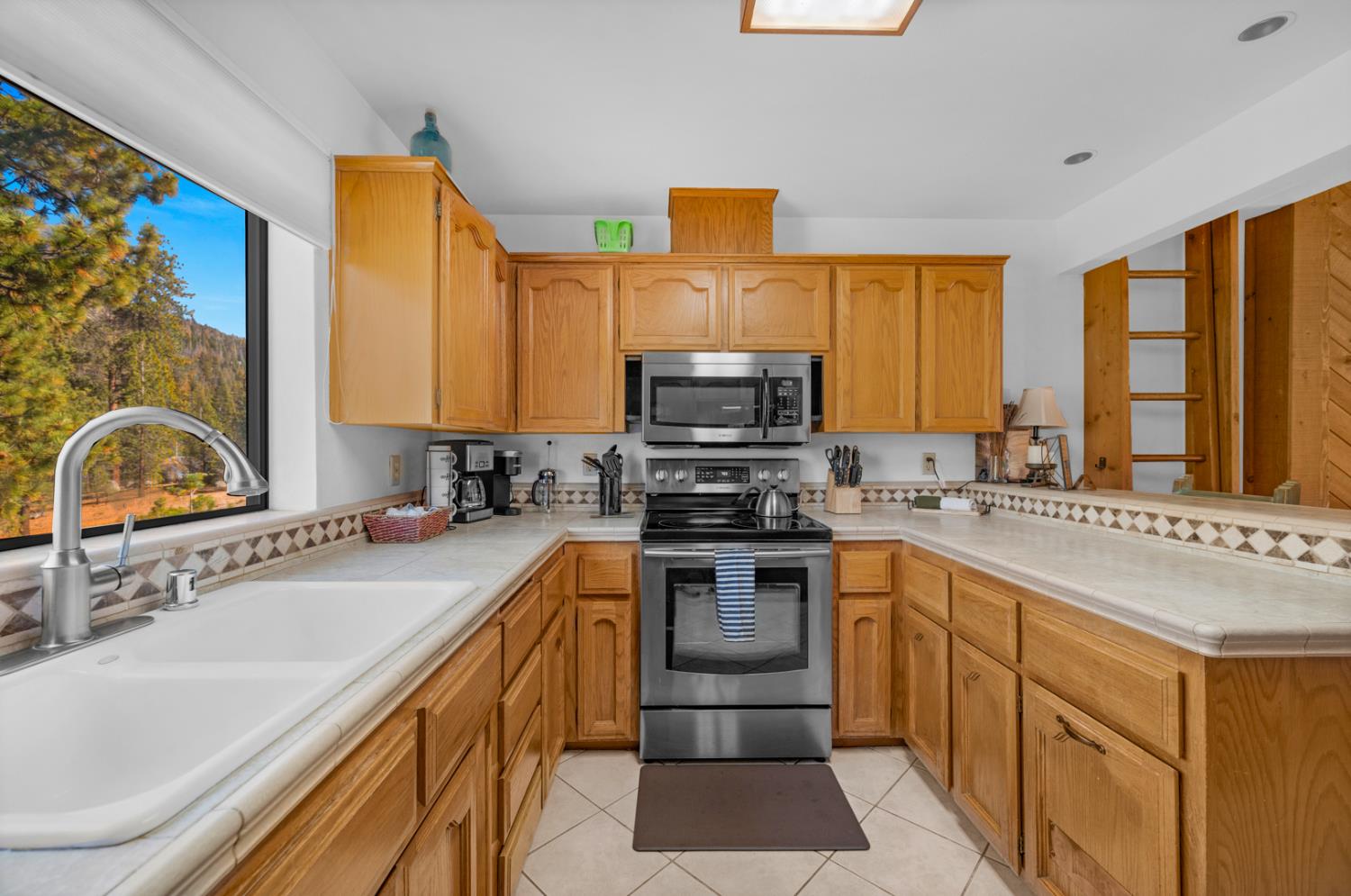 63215 Huntington Vista Road, Unit 80 Mono Hot Springs, CA 93642 - Photo 9 of 58 a kitchen with stainless steel appliances a stove sink microwave and cabinets