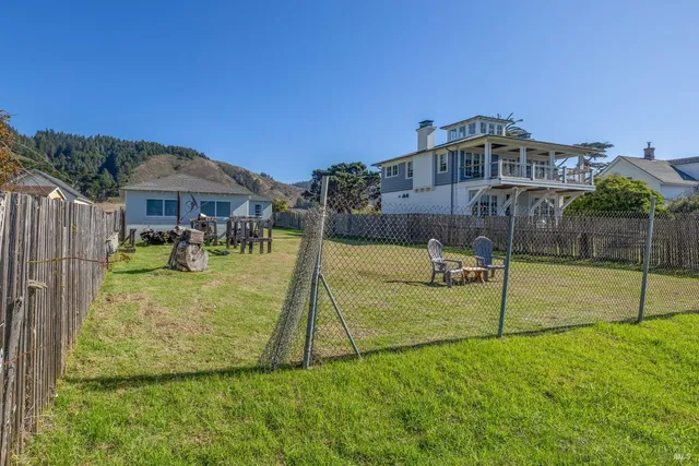 a view of a house with backyard sitting area and garden