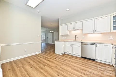a kitchen with granite countertop white cabinets and white appliances
