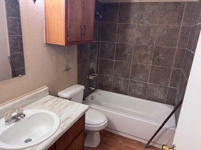 1017 12th Street Southeast, Unit 1017 Paris, TX 75460 - Photo 4 of 8 Full bathroom featuring a textured wall, shower / bathtub combination, vanity, and wood finished floors