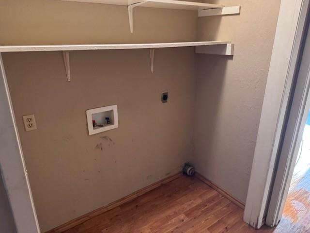 1017 12th Street Southeast, Unit 1017 Paris, TX 75460 - Photo 5 of 8 Washroom featuring light wood-style flooring, washer hookup, a textured wall, and hookup for an electric dryer