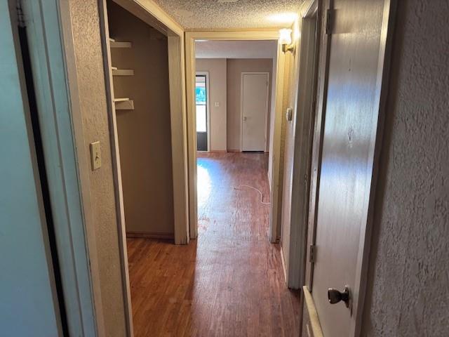 1017 12th Street Southeast, Unit 1017 Paris, TX 75460 - Photo 6 of 8 Corridor featuring light wood-style floors, a textured ceiling, and a textured wall