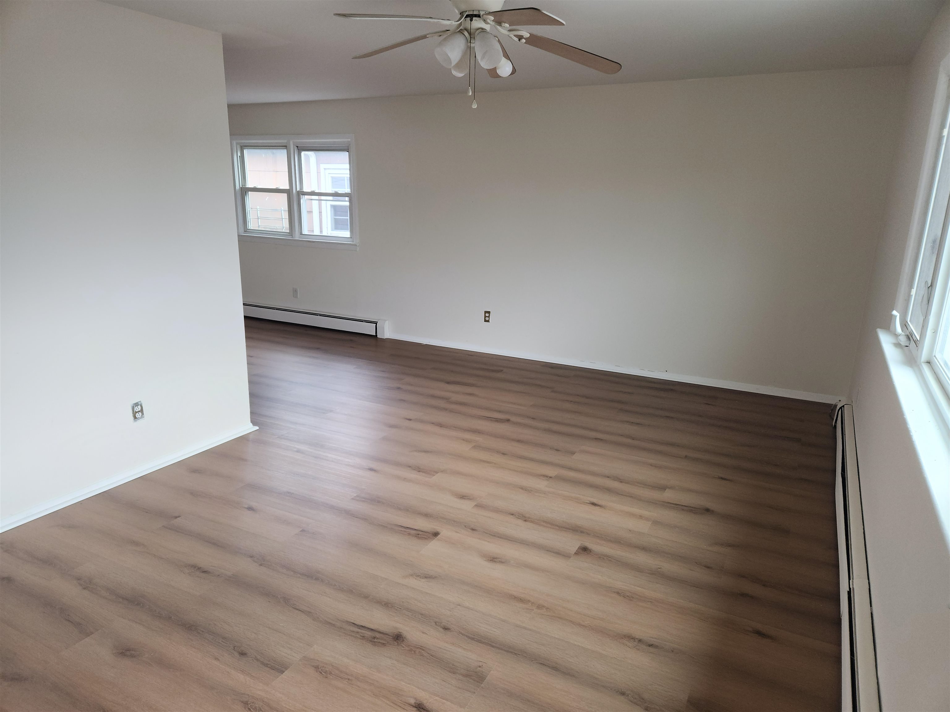71 Linnet Street, Unit 2 Bayonne, NJ 07002 - Photo 3 of 18 an empty room with wooden floor and windows